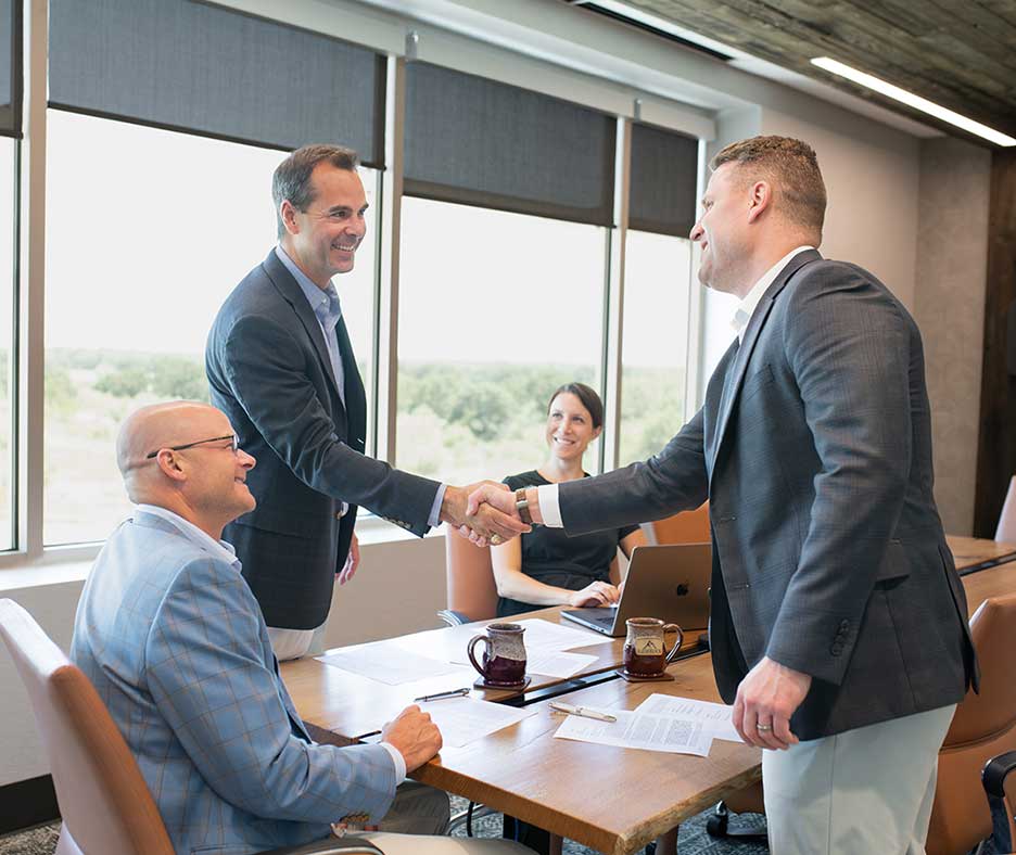 men shaking hands in conference room